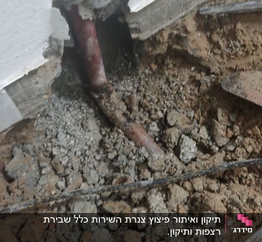 צינור מים חשוף בקיר עם אדמה מסביב